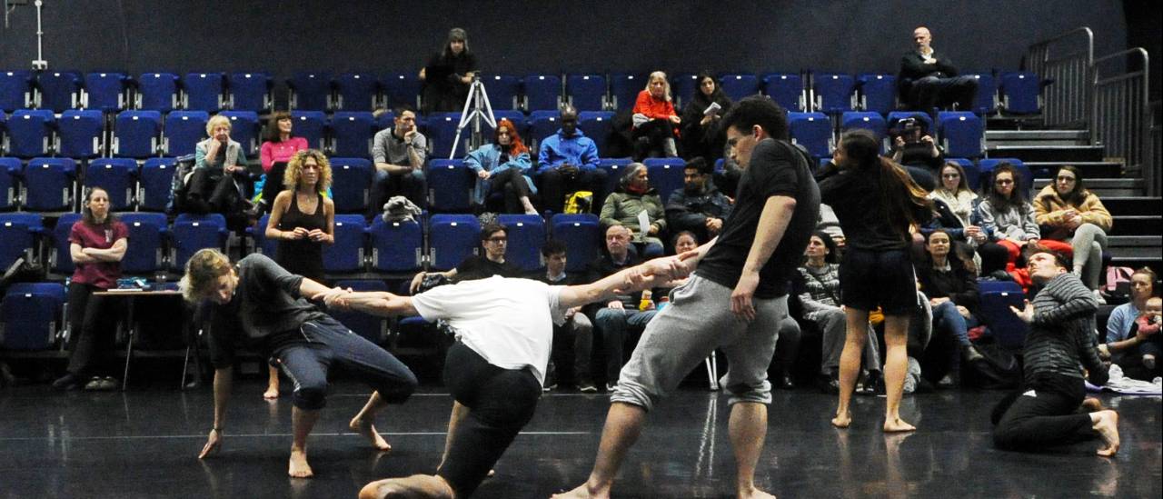 Dances rehearsing in a studio with audience watching