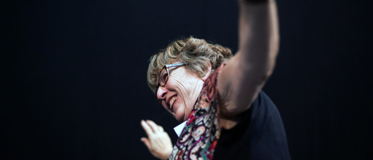 Parkinson's participant smiles with arms raised in the air