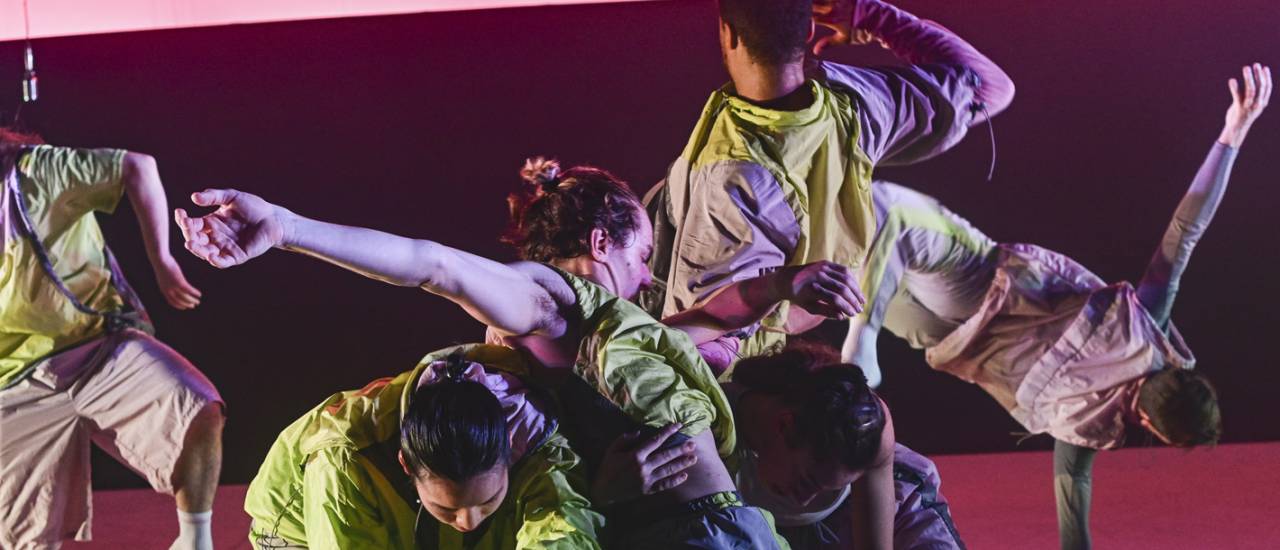 dancers in green costumes on pink background