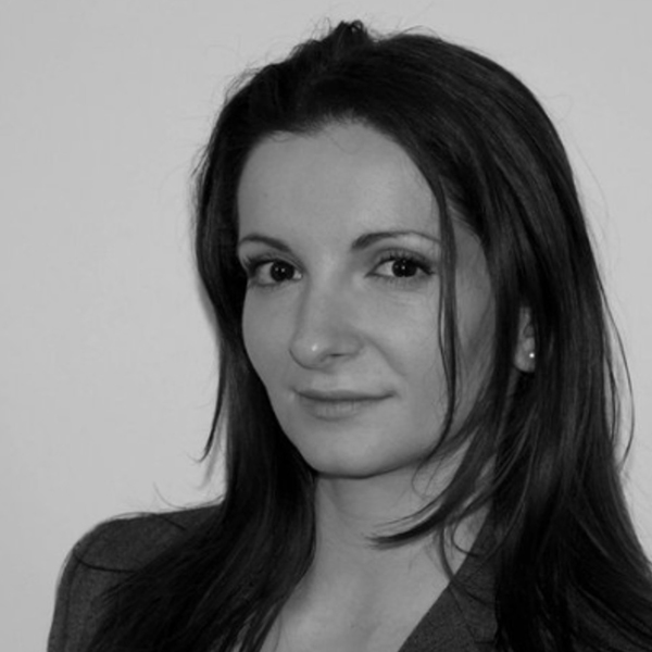 Gentina has a black and white headshot showing her savvy expression and has shoulder length hair in a smart choppy cut